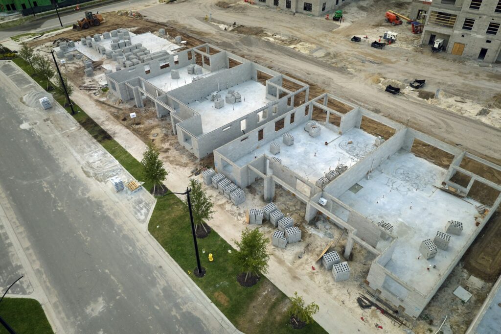 Aerial view of unfinished frame of private house with brick concrete walls