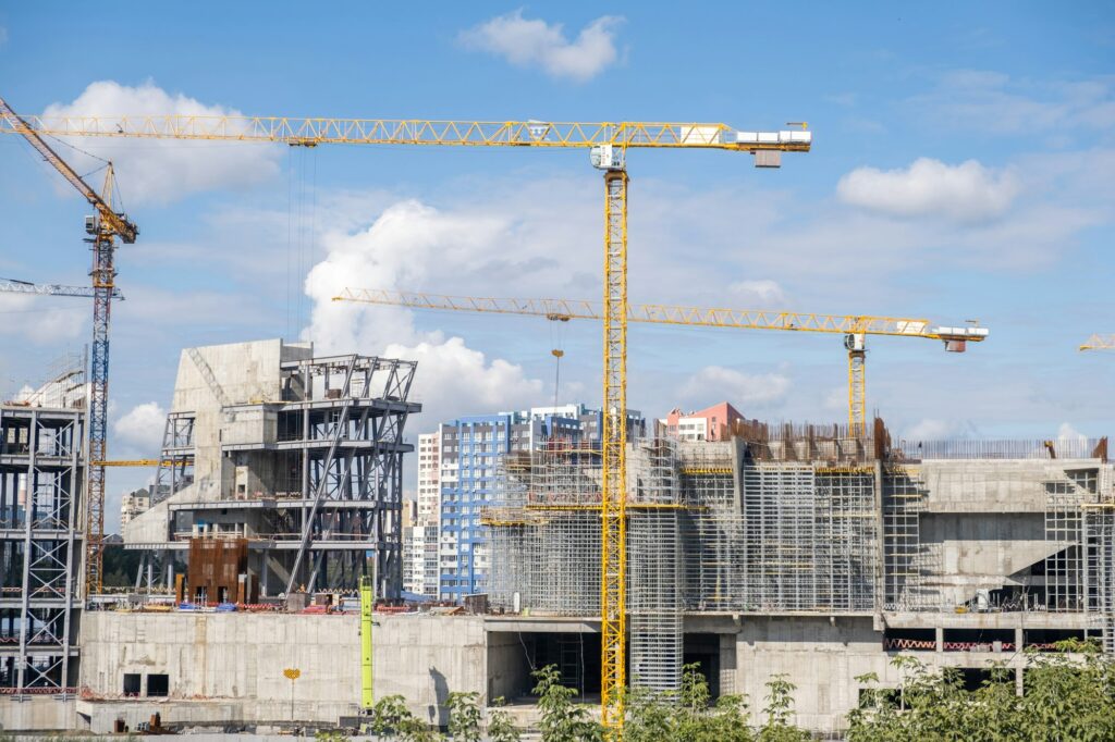 crane and a building under construction against a blue sky background