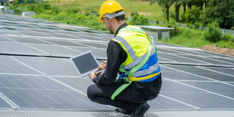 Engineers checking solar panel on the roof of factory.