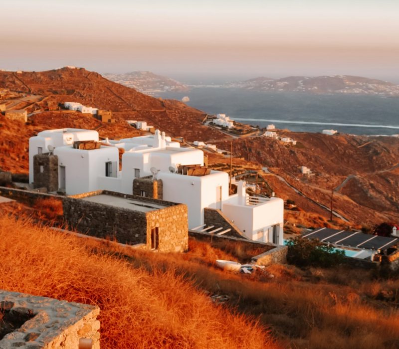 Sunset moment and warm light on the sky in Mykonos island during summertime. White house and sea.